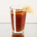 A clear 9 oz. highball glass filled with iced tea and garnished with a lemon wedge.