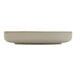 A round, beige porcelain plate with a deep raised rim.