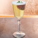 A clear Libbey Speakeasy 8.25 oz. cocktail glass filled with a light-colored beverage and garnished with a strawberry.