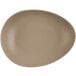 A sand-colored, matte finish, organically shaped porcelain coupe plate.