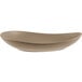 A sand-colored, matte finish porcelain coupe plate with an organic, asymmetrical shape.