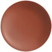 A round, clay-colored satin matte porcelain coupe plate.