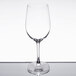 A clear 12 oz. wine glass with a stem and rounded bowl.