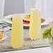 A pair of Libbey 8.5 oz. stemless flute glasses filled with a light yellow beverage on a breakfast table.