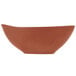 A matte clay-colored porcelain bowl with an organic, curved shape.