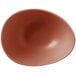 A clay-colored satin matte porcelain bowl with an organic, asymmetrical shape.