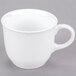A plain white porcelain tea cup with a handle.
