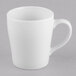 A plain white porcelain mug with a handle.