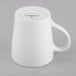 A plain white porcelain mug turned upside down on a gray surface.
