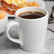 A white porcelain mug filled with black coffee.