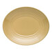 A tan oval terracotta platter with a ridged design around the edge.