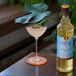A bottle of Liber & Co Classic Gum Syrup next to a cocktail in a coupe glass.