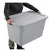 A large gray plastic storage tote with a lid being held by a person.