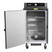 A stainless steel electric wood-fired stationary rack smoker with an open door showing multiple wire racks inside.