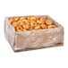 A cardboard box lined with plastic containing a large quantity of plain yeast-risen mini donut rings.