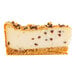 A slice of chocolate chip cannoli ricotta cheesecake with a graham cracker crust and chocolate chips throughout.