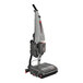 A cordless walk-behind cylindrical floor scrubber with a squeegee attachment.