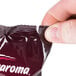 A hand holding an Ellis Mezzaroma City Roast Coffee packet.