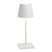 A small white cordless rechargeable table lamp with a square base and conical shade.