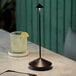 A black cordless rechargeable table lamp with a slim, modern design and a conical base.