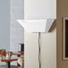 A white metal trapezoidal wall sconce LED insect light trap with a visible power cord, designed for indoor use.