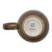 A brown porcelain coupe mug with a handle, shown upside down to display the Ariane brand logo on the base.