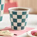 A navy and white checkered paper hot cup filled with coffee.
