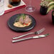 A small round black porcelain plate with a gourmet food presentation.