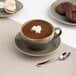 A brown porcelain cappuccino cup filled with hot chocolate and topped with marshmallows, placed on a matching saucer.