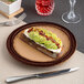 A brown round embossed wide rim porcelain flat plate.