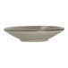 A small round porcelain coupe plate with a subtle earthy glaze.