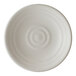 A round, off-white porcelain coupe plate with a subtle speckled pattern and concentric circular ridges.