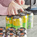 A black HDPE plastic 6-pack can carrier holding several beverage cans.