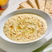 A bowl of creamy tahini paste garnished with spices and served with pita bread.