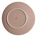 A round beige porcelain coupe flat plate with a slanted edge, shown from the bottom.
