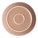 A round, tan porcelain coupe bowl with concentric circle designs on the bottom.