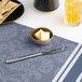 A small blue round tapered porcelain ramekin filled with butter, placed on a patterned placemat.