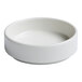 A small, round, ivory porcelain bowl with a raised rim.