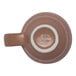 A brown porcelain espresso cup with a handle, viewed from the bottom, featuring the Ariane brand logo.