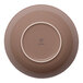 A round beige porcelain coupe deep plate shown from the bottom.