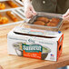A box of Choice Safecut 12-inch by 2000-foot premium foodservice film with a slide cutter being used to cover a food tray.