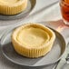 A single-serving mini cheesecake on a small plate.