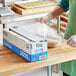 A large box of Choice 18-inch by 3000-foot foodservice cling film with a serrated cutter being used to cover a bowl.
