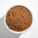 A white bowl filled with light brown cocoa powder.