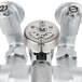 A T&S rough chrome wall mount service sink faucet with two metal valves and a metal handle.