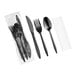 A set of black plastic cutlery including a knife, fork, spoon, and a napkin, individually wrapped in plastic.