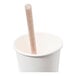 A natural agave giant straw placed inside a plain white paper cup.