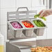 A stainless steel steam pan insert for a griddle shelf, shown holding sliced vegetables.