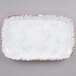 A white irregular rectangular melamine platter with a speckled pattern and brown edges.
