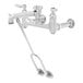 A silver T&S wall mount mop sink faucet with lever handles.